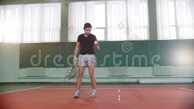 在网球场上训练。 年轻人把球从口袋里拿出来，用它<strong>砸</strong>地板